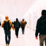 Group of travelers walking through a bright modern airport terminal carrying backpacks