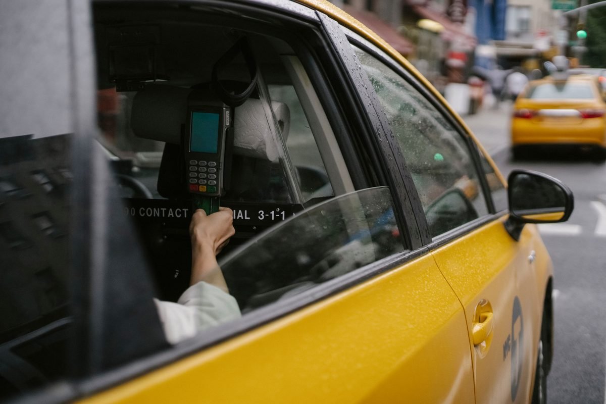 Passenger using a payment terminal inside a taxi car.