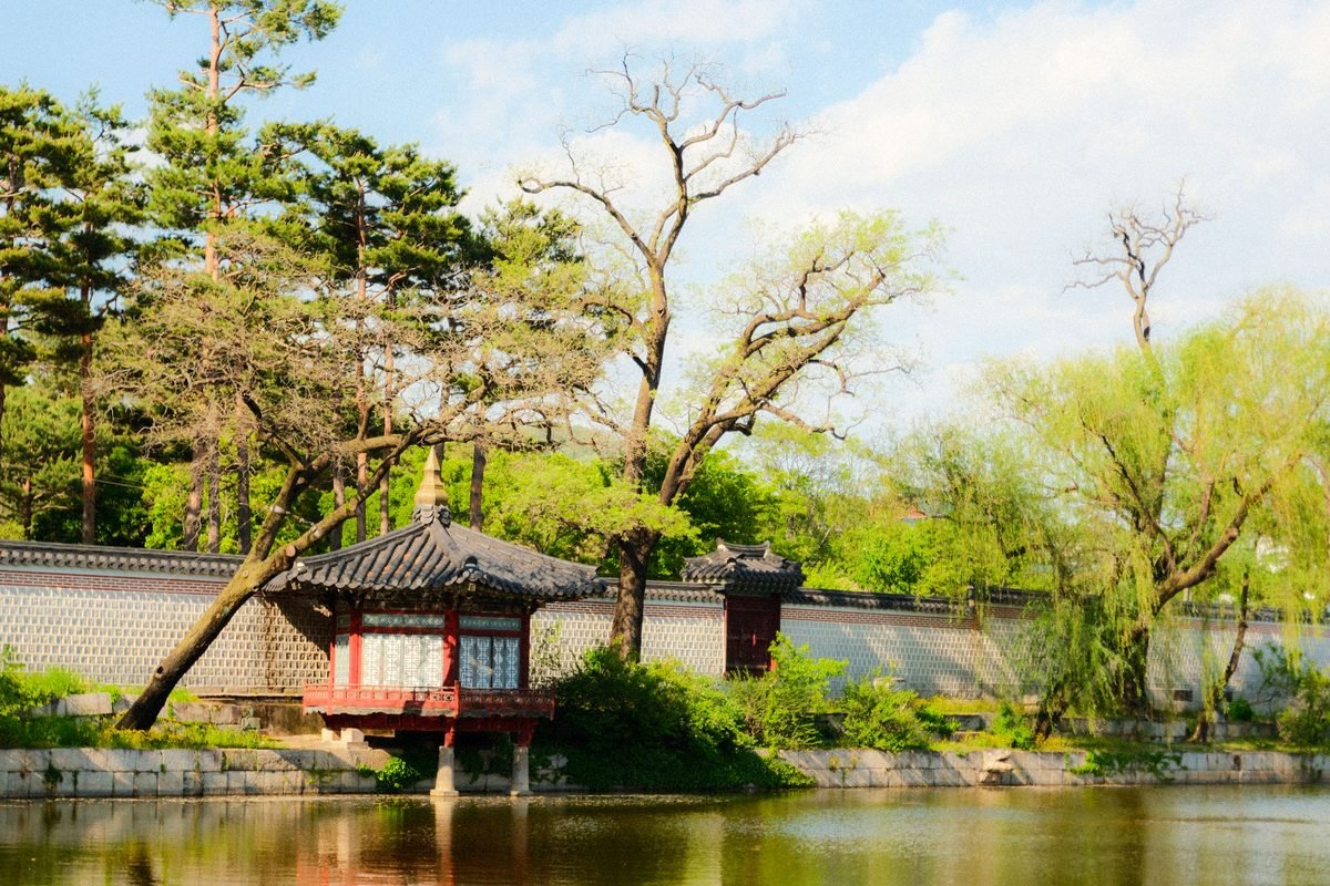 Traditional Korean pavilion reflecting in a calm pond in Seoul.