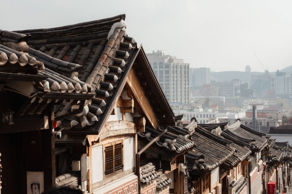 Traditional Hanok roofs overlooking modern cityscape in Seoul.
