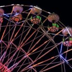 Illuminated ferris wheel glowing against a dark sky