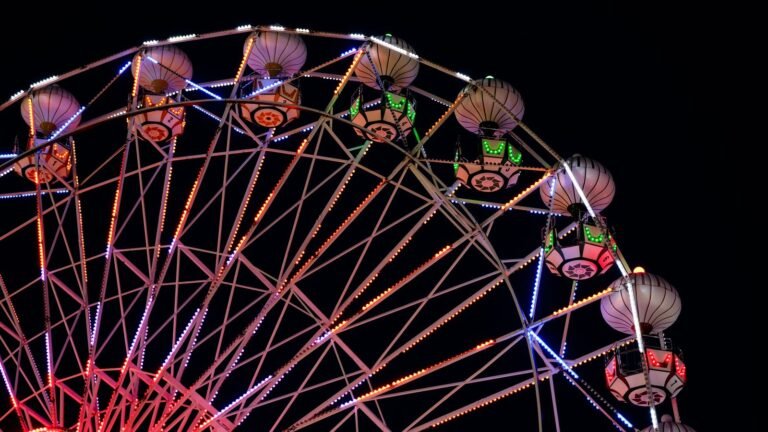 Illuminated ferris wheel glowing against a dark sky