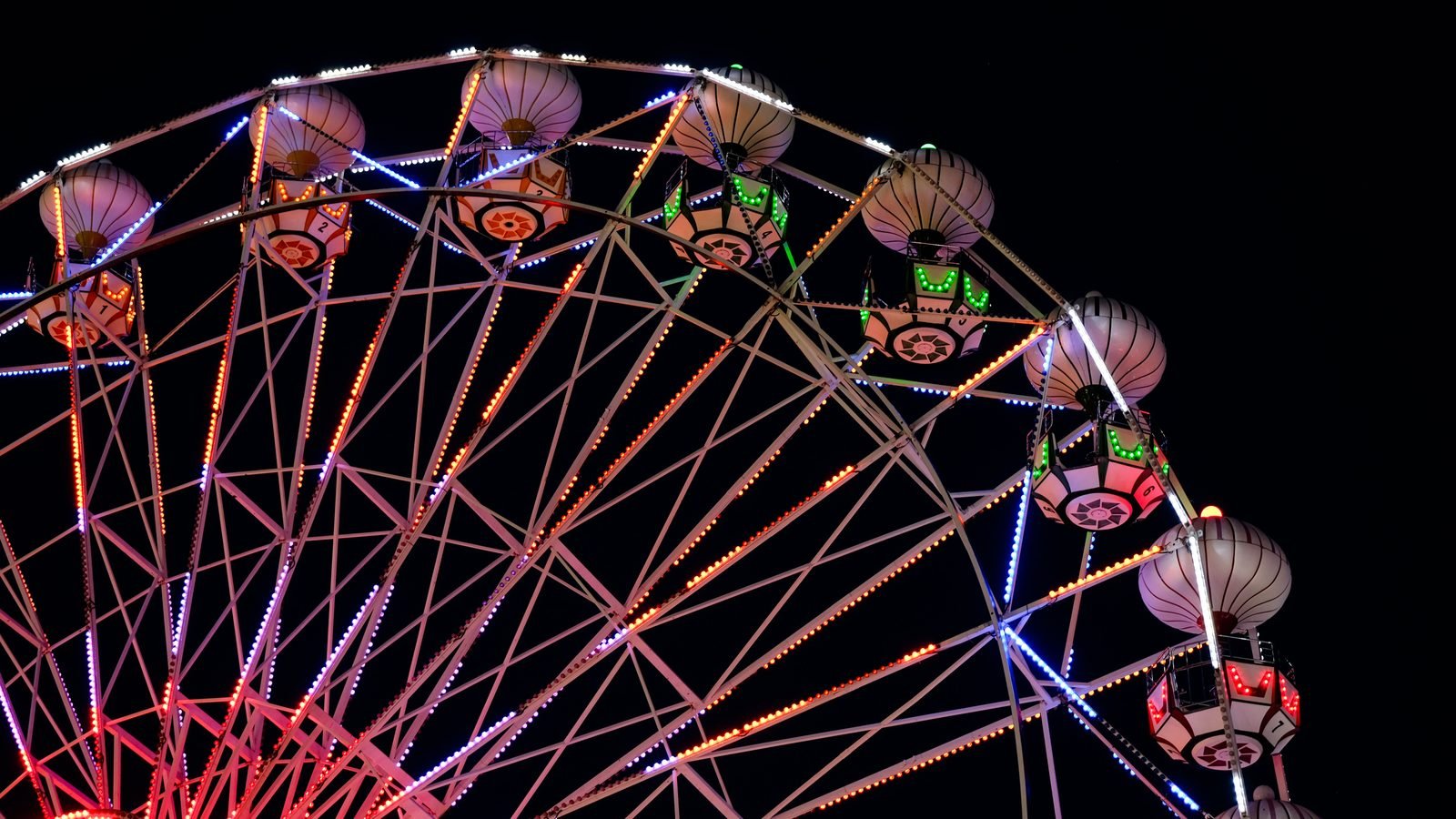 Illuminated ferris wheel glowing against a dark sky
