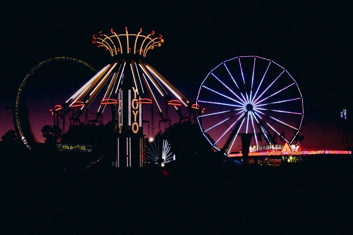 Colorful amusement park rides glowing at night