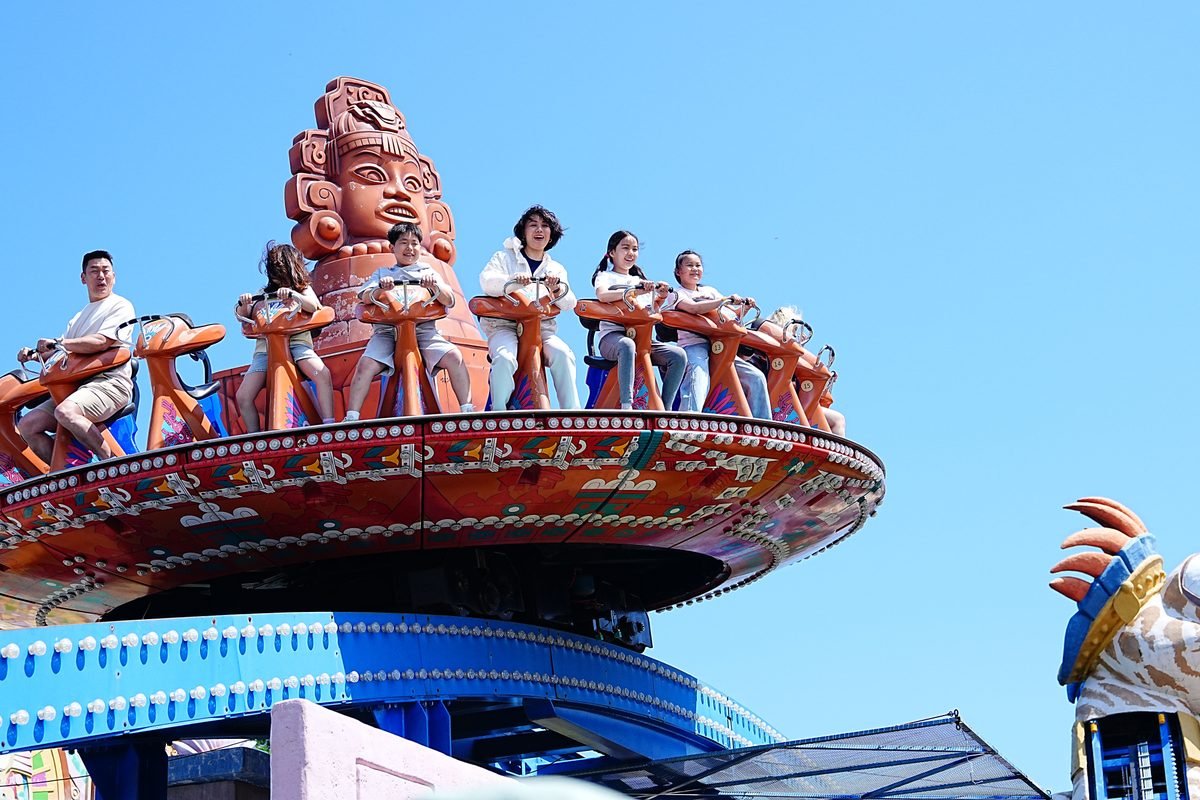 Visitors enjoying a thrilling amusement park ride outdoors