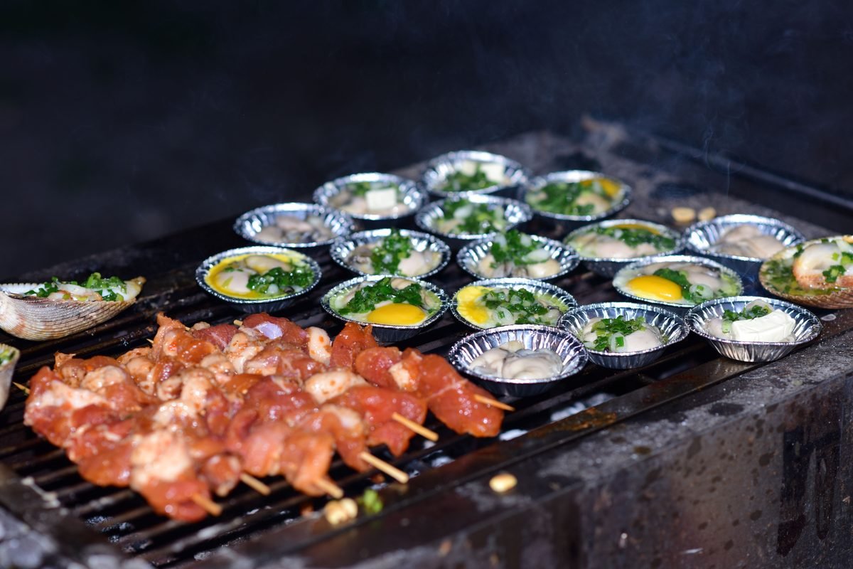 Seafood and small dishes grilling on an open outdoor barbecue