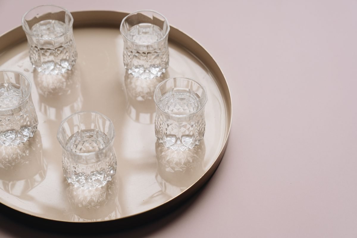 Crystal glasses filled with clear water arranged on a tray