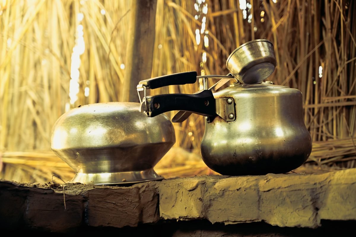 Traditional metal kettles and cookware in a rustic setting