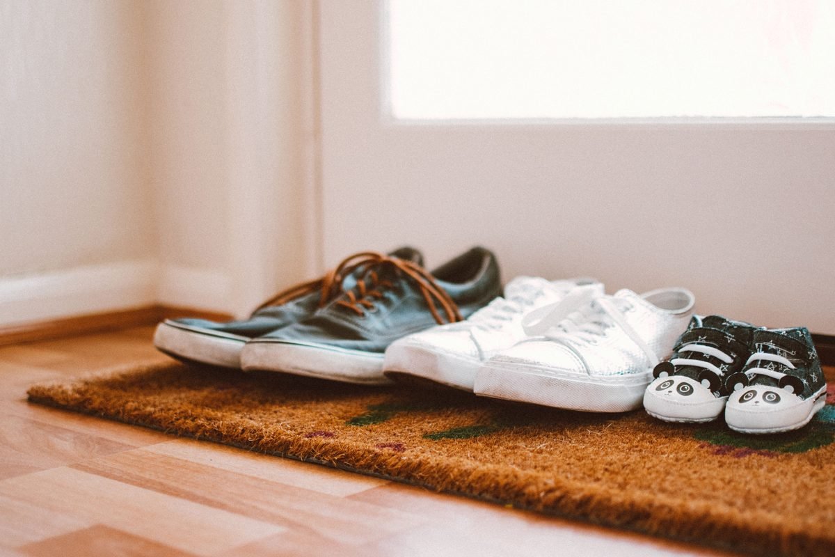 Pair of soft slippers on a patterned rug indoors.