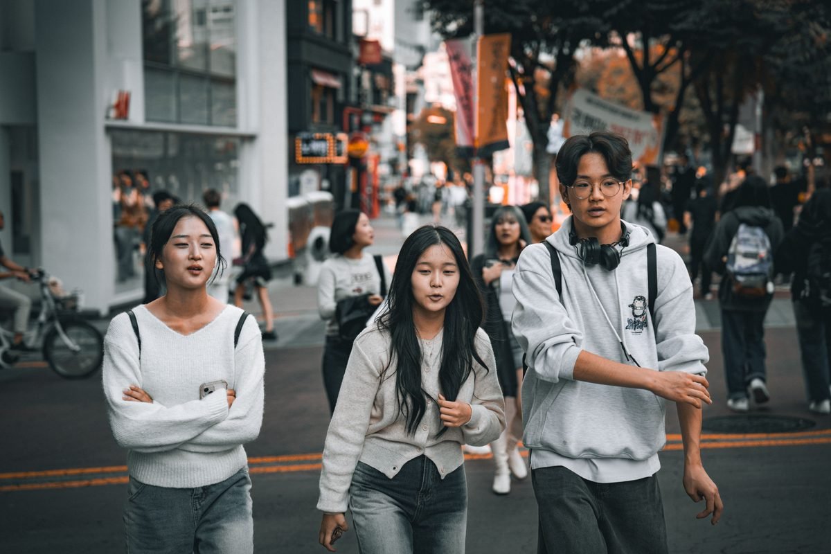 Young friends walking through a busy street in Seoul.