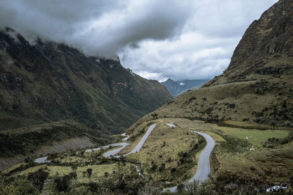 Winding mountain switchback road cutting through the lush Peruvian Andes