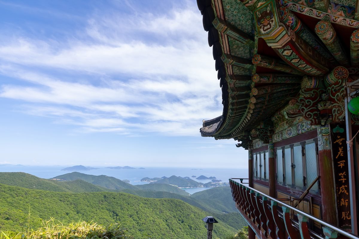 Traditional temple eaves framing a stunning view of sea islands in Namhae.