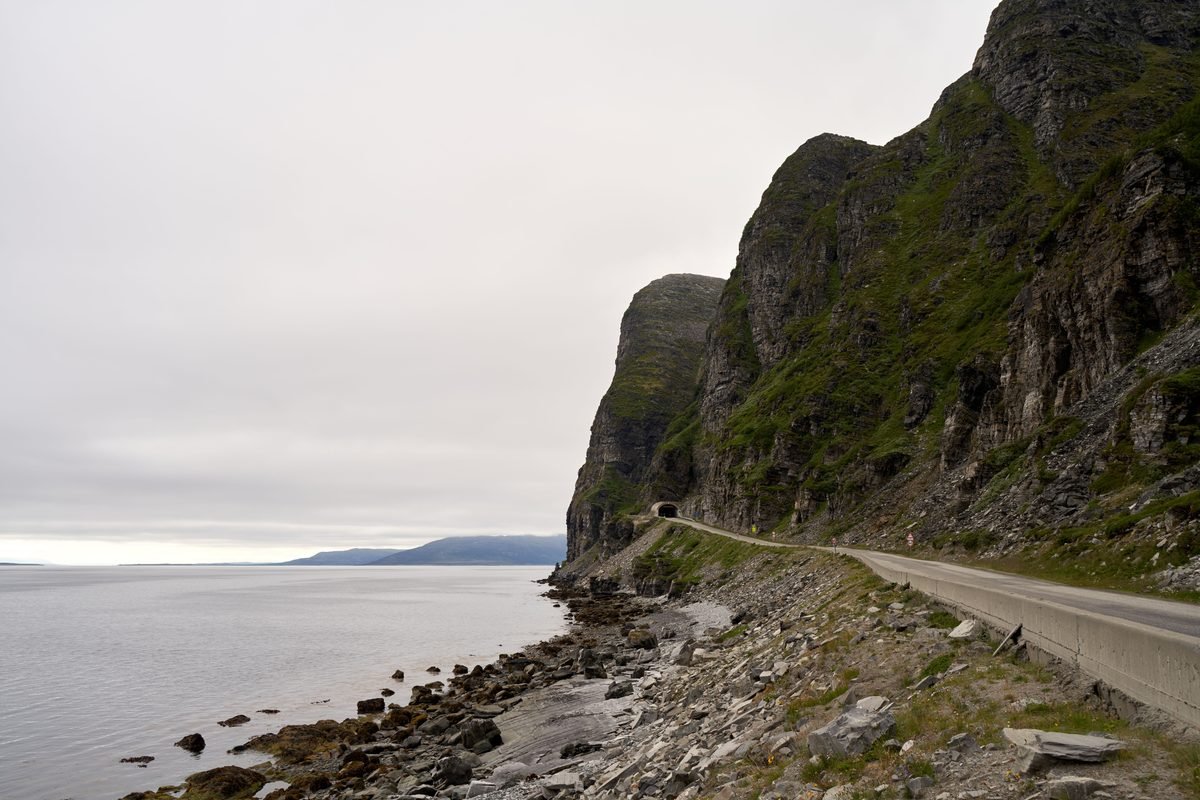 Winding coastal asphalt road curving along steep rocky cliffs by the sea