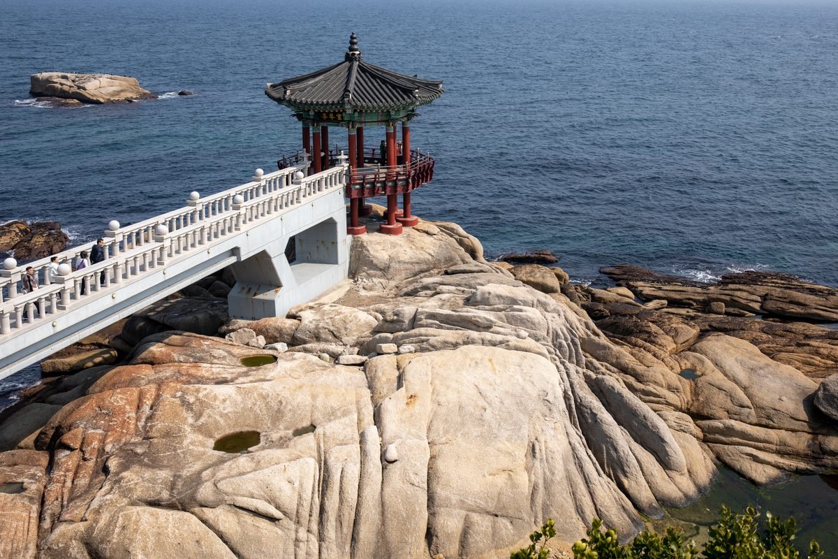 Traditional Korean pavilion on a rocky ocean cliff overlooking the sea