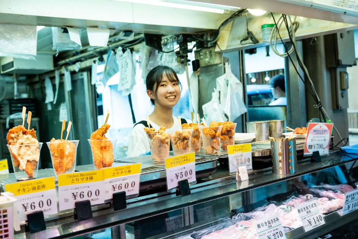 Vendor serving fried chicken at a street food stall in Japan
