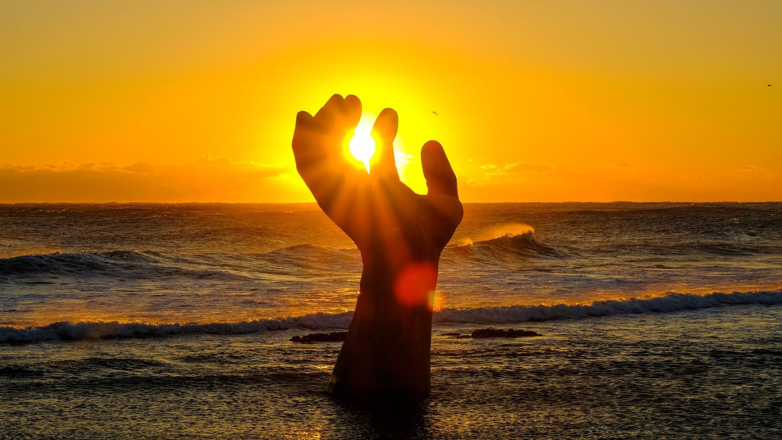 Captivating sunrise over the giant bronze hand sculpture in Pohang