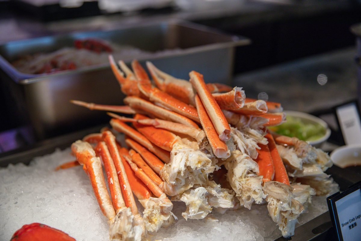 Chilled snow crab legs stacked on ice at a seafood market