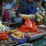 Vendors interacting at a vibrant seafood market with various sea delicacies