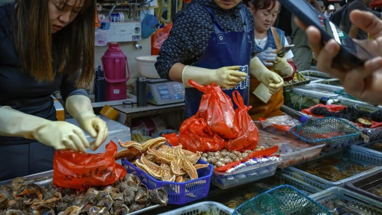 Vendors interacting at a vibrant seafood market with various sea delicacies