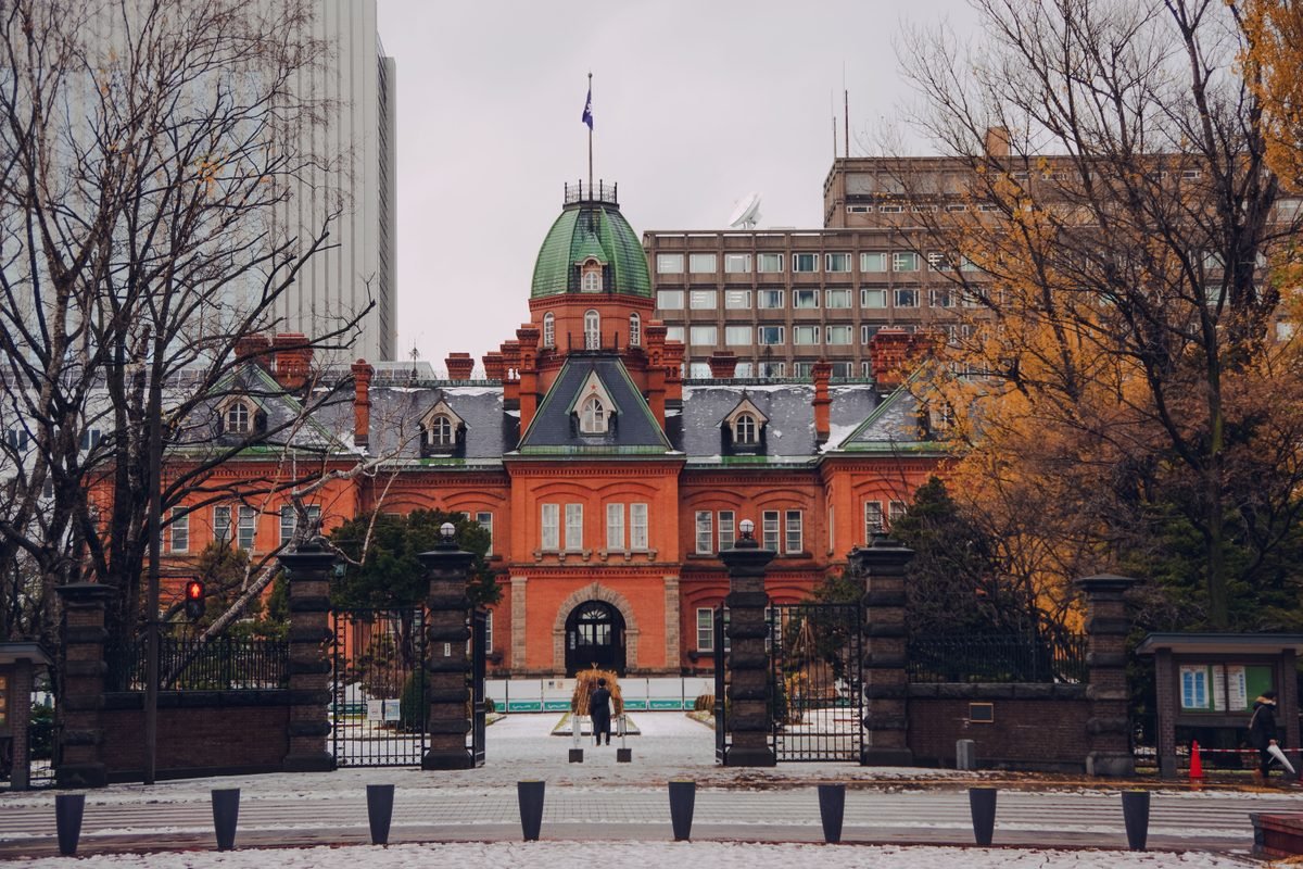 The historic former government office building in Sapporo framed by autumn trees.