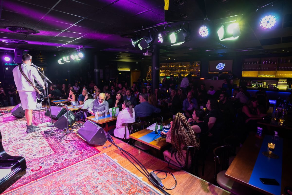 Cozy live music club with tables and audience