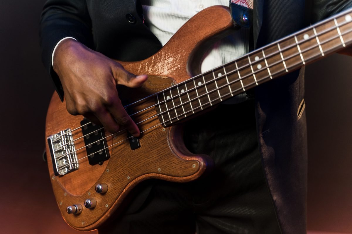 Musician playing bass guitar on a low stage