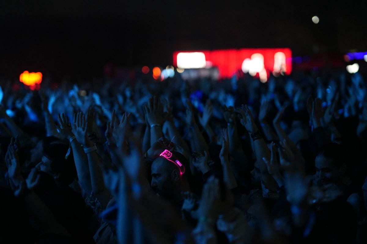 Concert crowd raising hands with glowing wristbands
