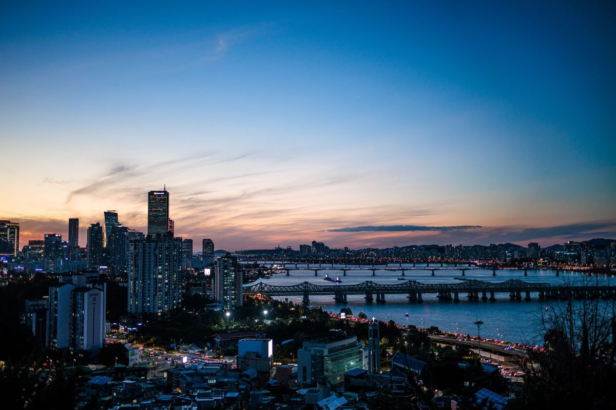 The skyline of Seoul and bridges crossing the Han River at twilight.