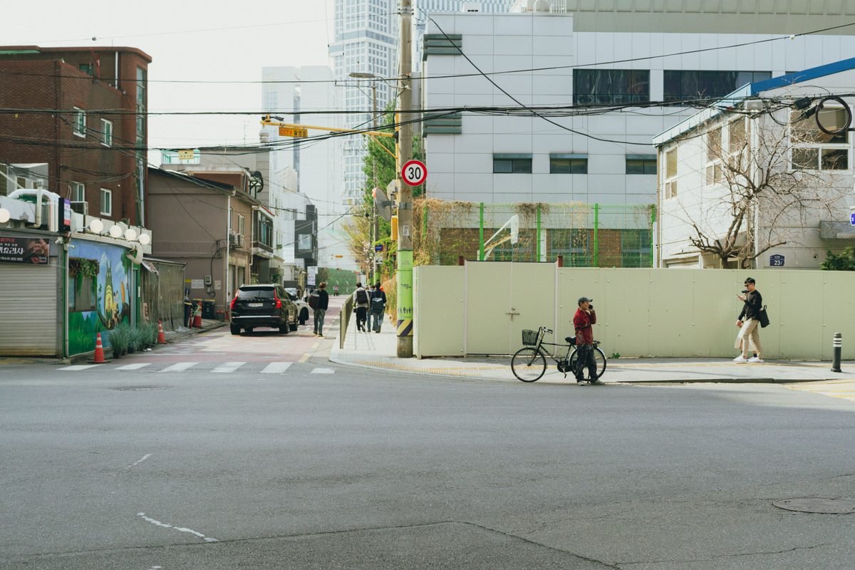 A cyclist on a Seoul city street with buildings and street infrastructure