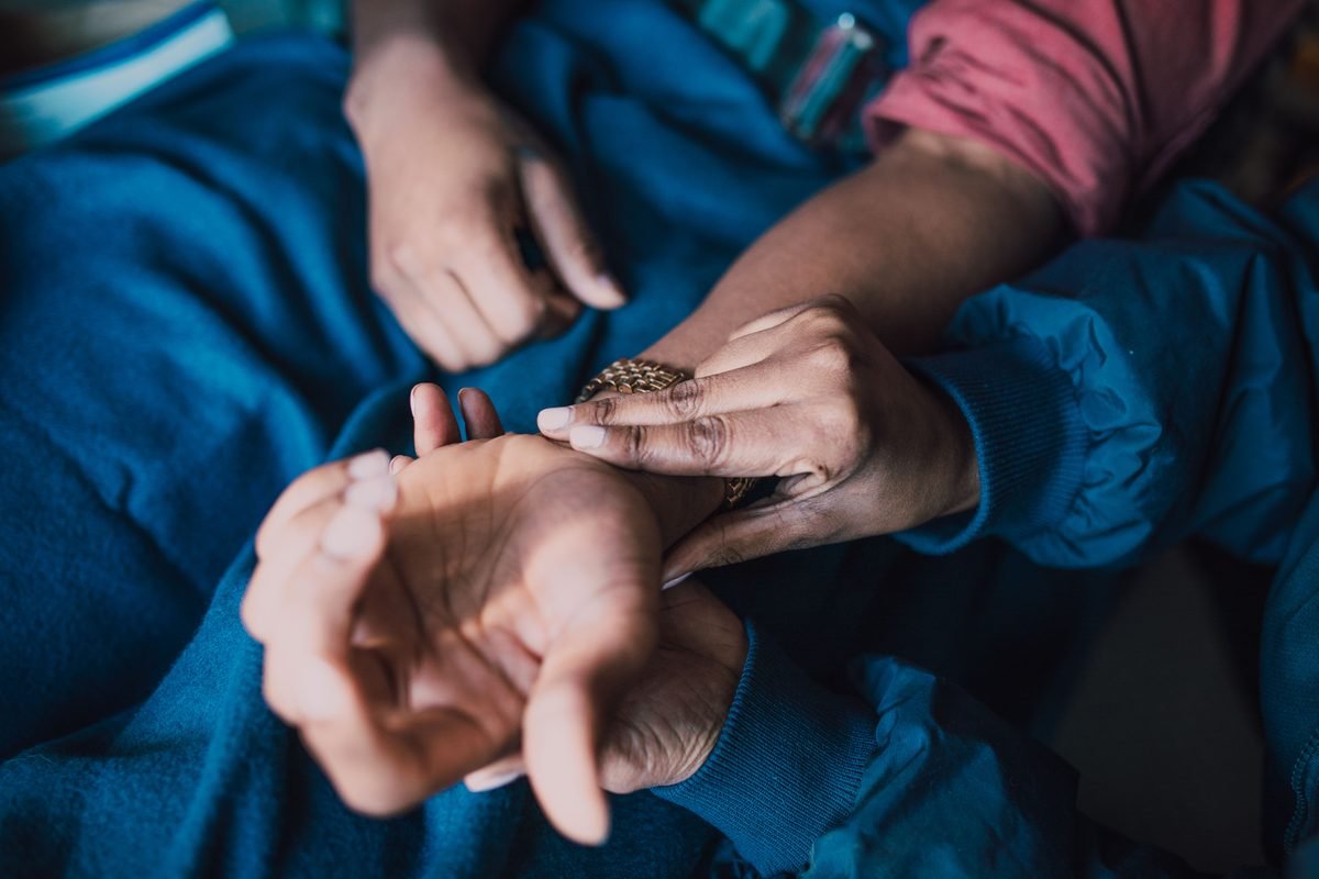 Practitioner checking a patient's wrist pulse