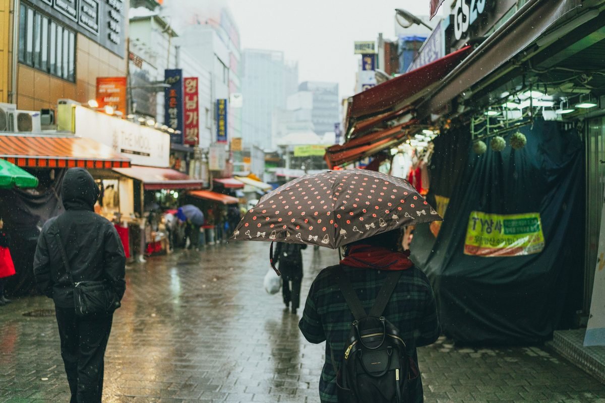 Rainy street scene in a bustling market area of Seoul
