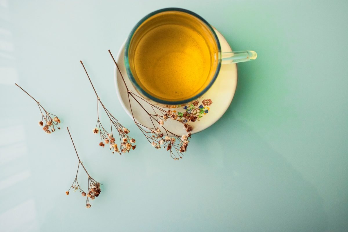 Minimalist top view of herbal tea in a glass cup with dried flowers