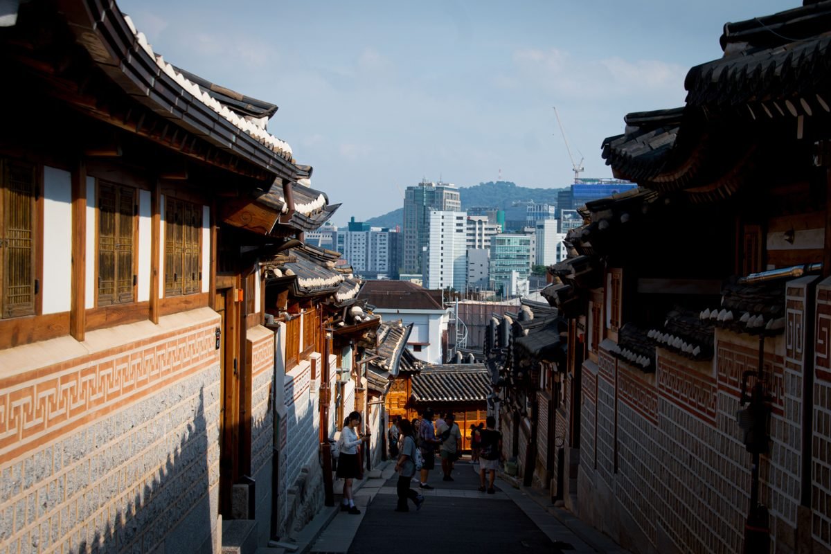 Tiled roofs of Bukchon Hanok Village viewed from a narrow street in Seoul