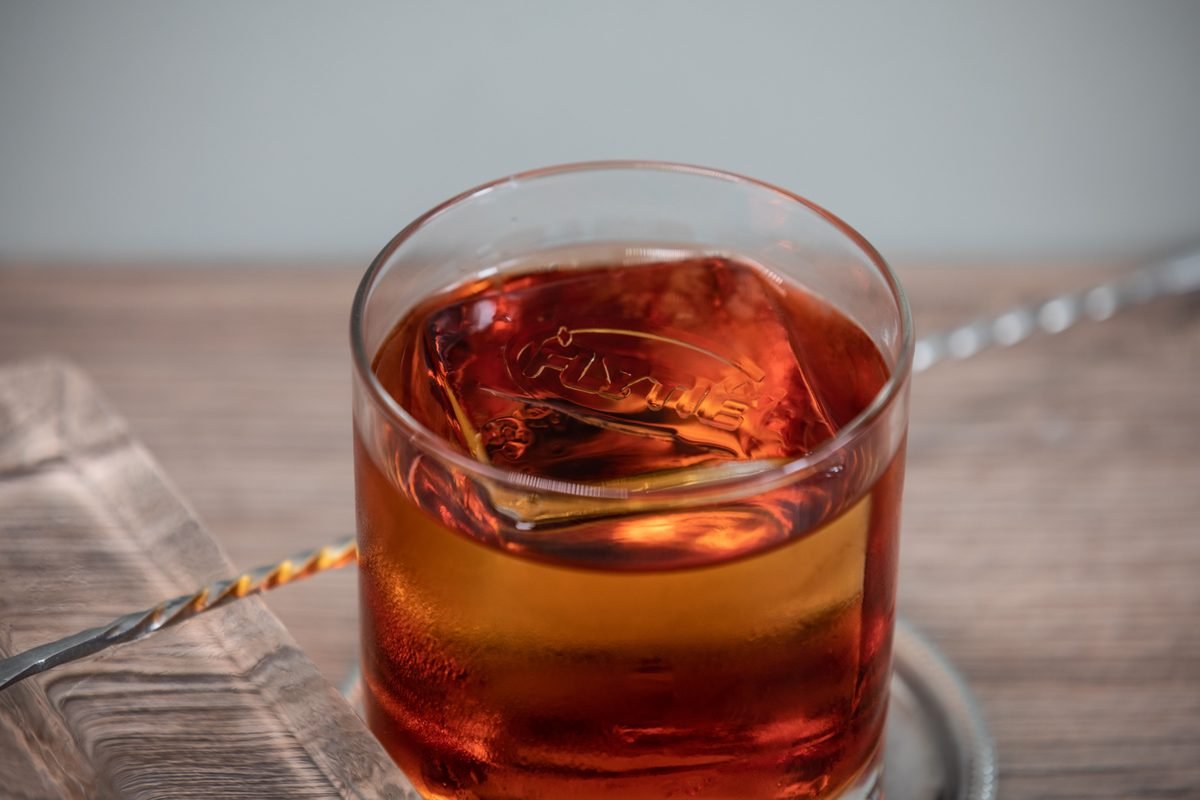 Detailed close-up of a whiskey glass with a large ice cube