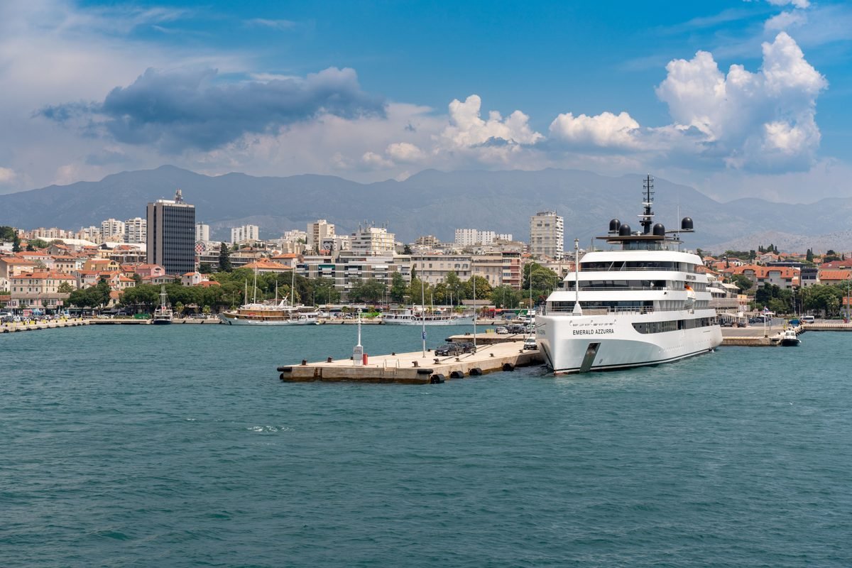 Luxury yacht anchored in Split harbor with distant mountains