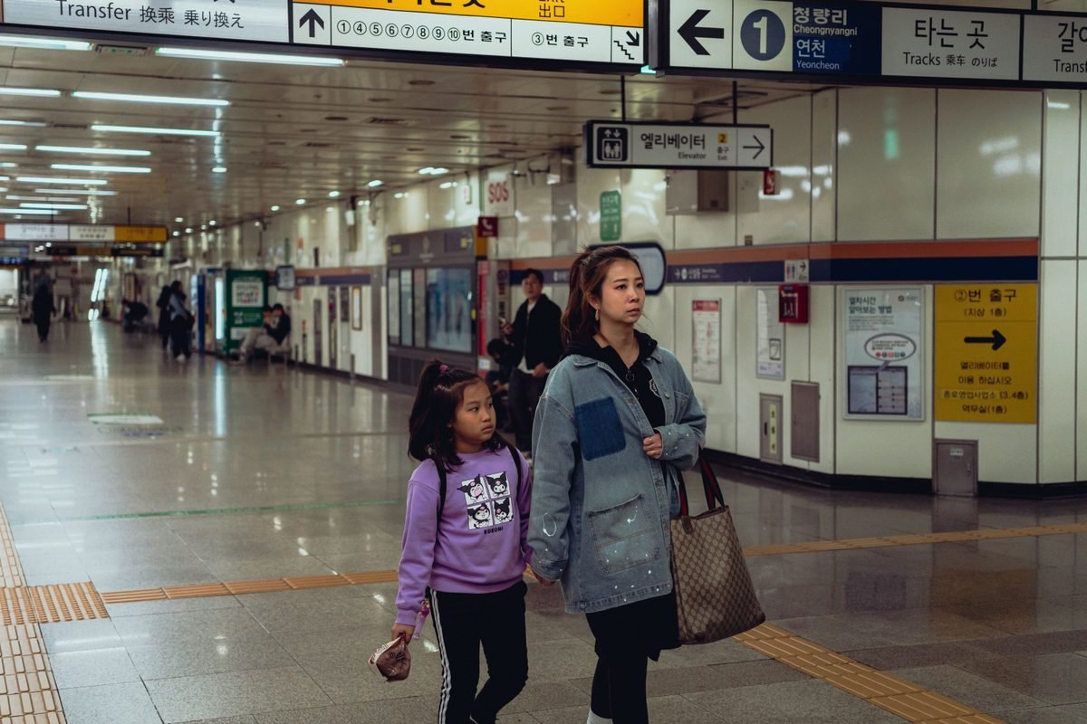 A woman and child walking through Suwon station corridor