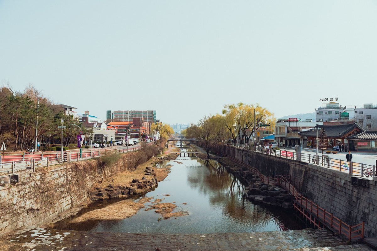 Canal view with traditional Korean architecture and autumn trees