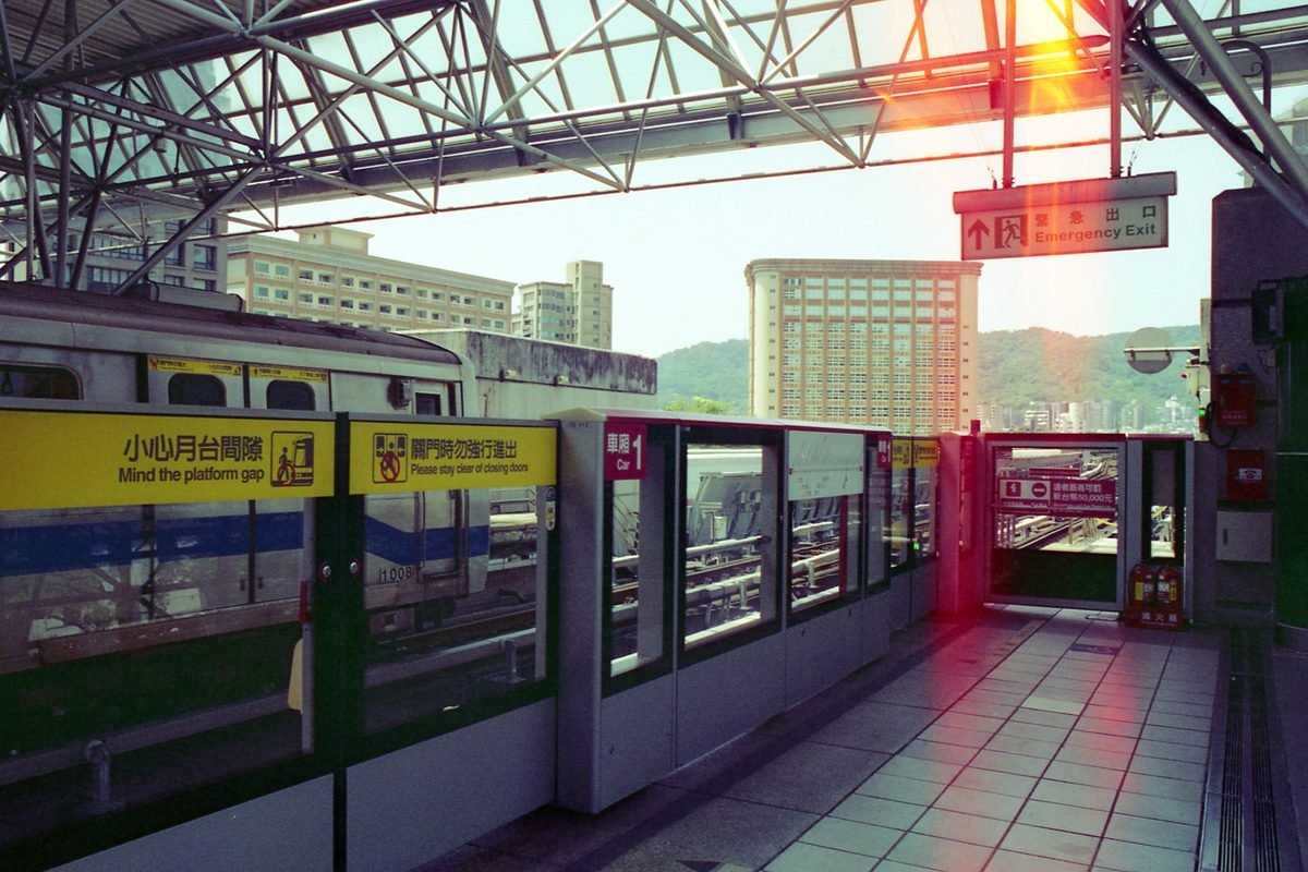 Sleek Taipei subway station platform with train and cityscape