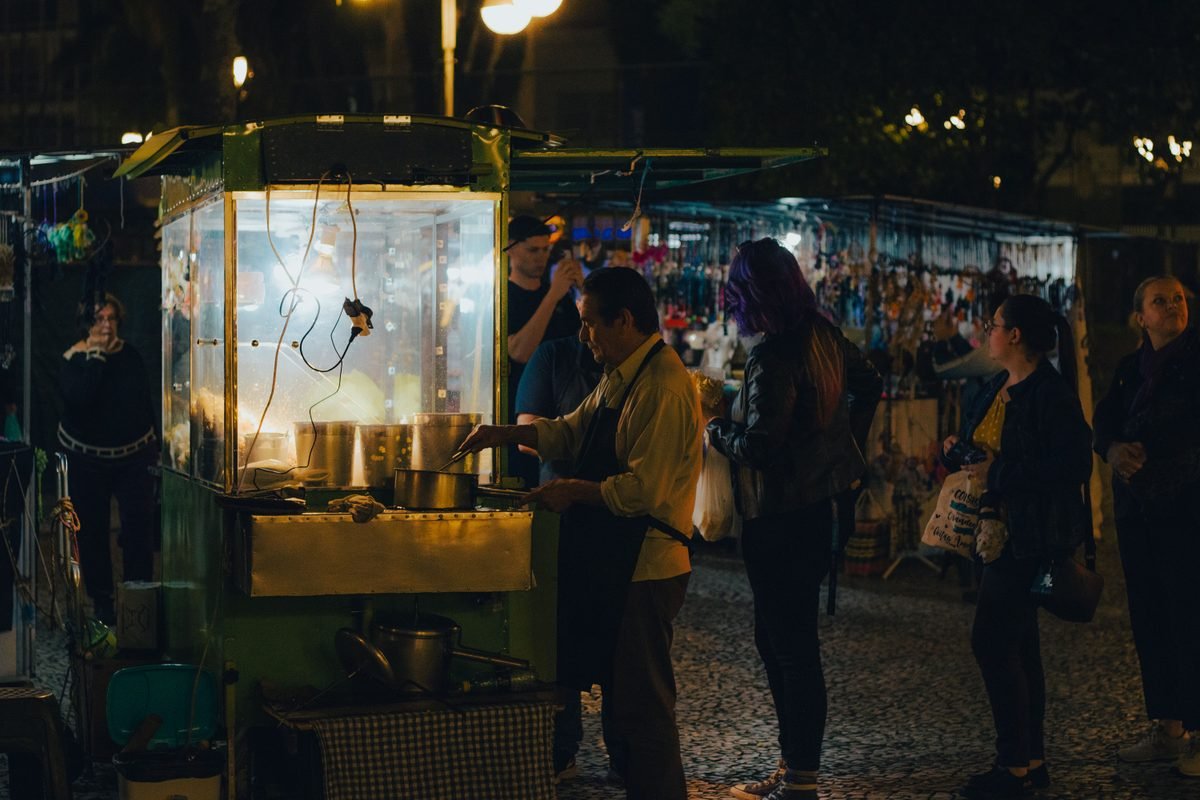 Illuminated entrance arch and crowd at a night market