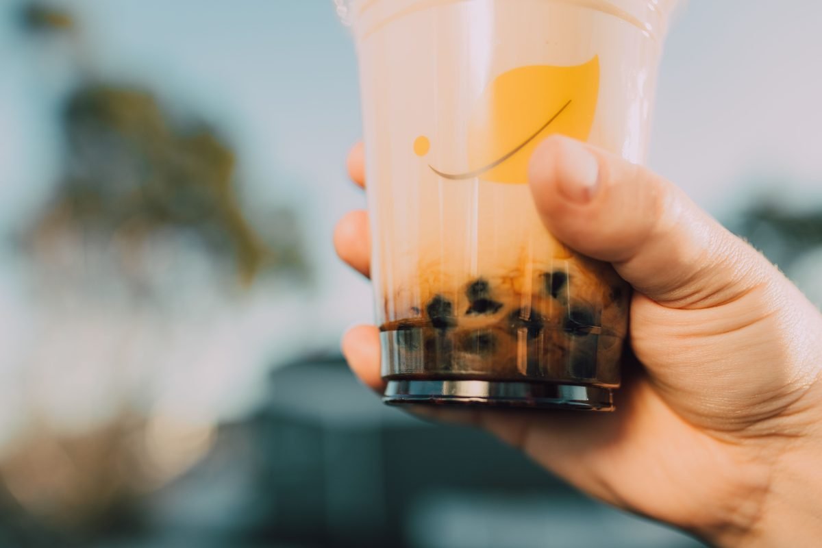 Close-up of a hand holding a plastic cup of bubble tea
