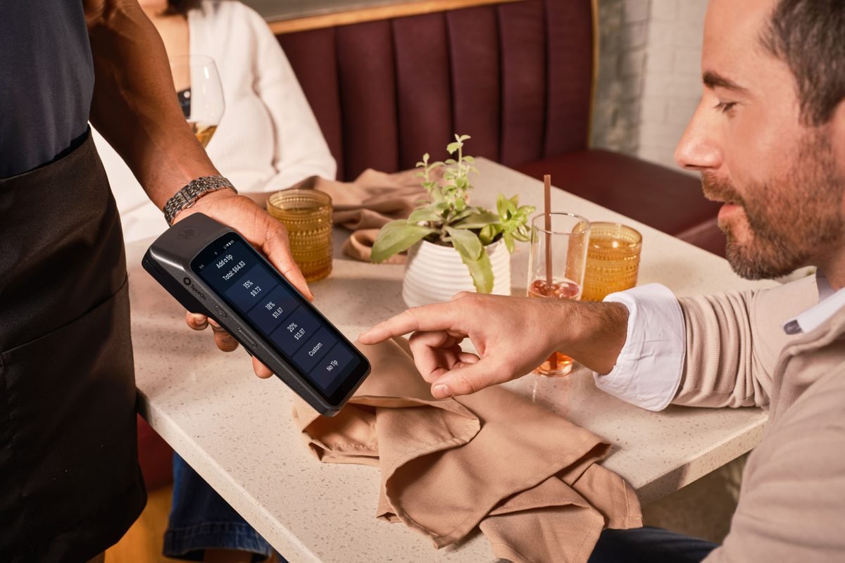 Diner using a handheld POS system for digital tipping.