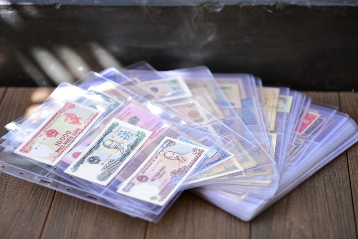 Diverse collection of international banknotes stored in sleeves.