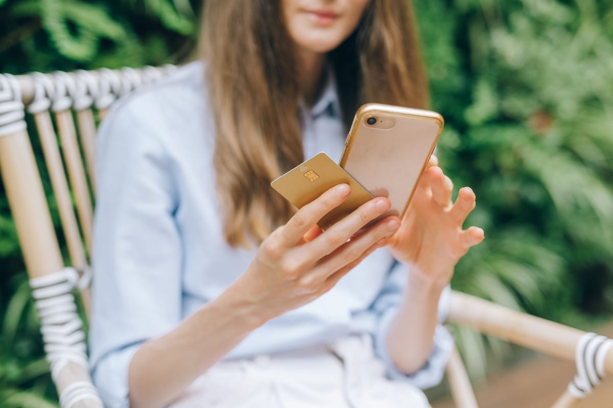 Woman making an online purchase using a smartphone and credit card.