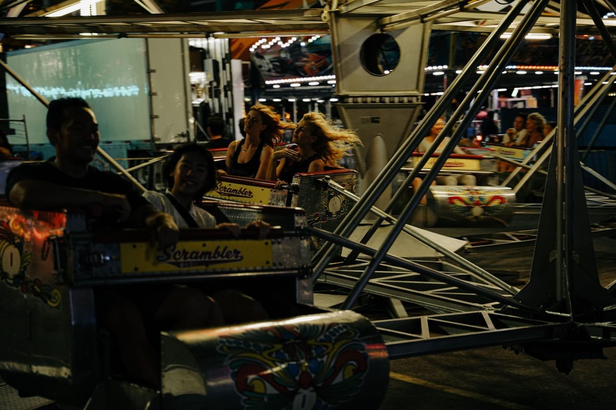 People enjoying a thrilling ride in an amusement park at night.