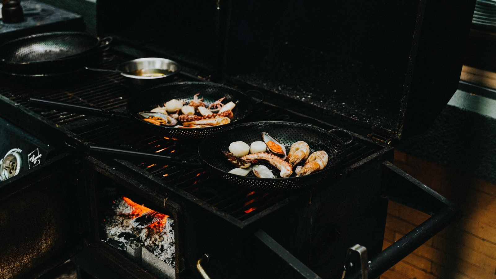 Seafood grilling over an open flame on an outdoor barbecue.